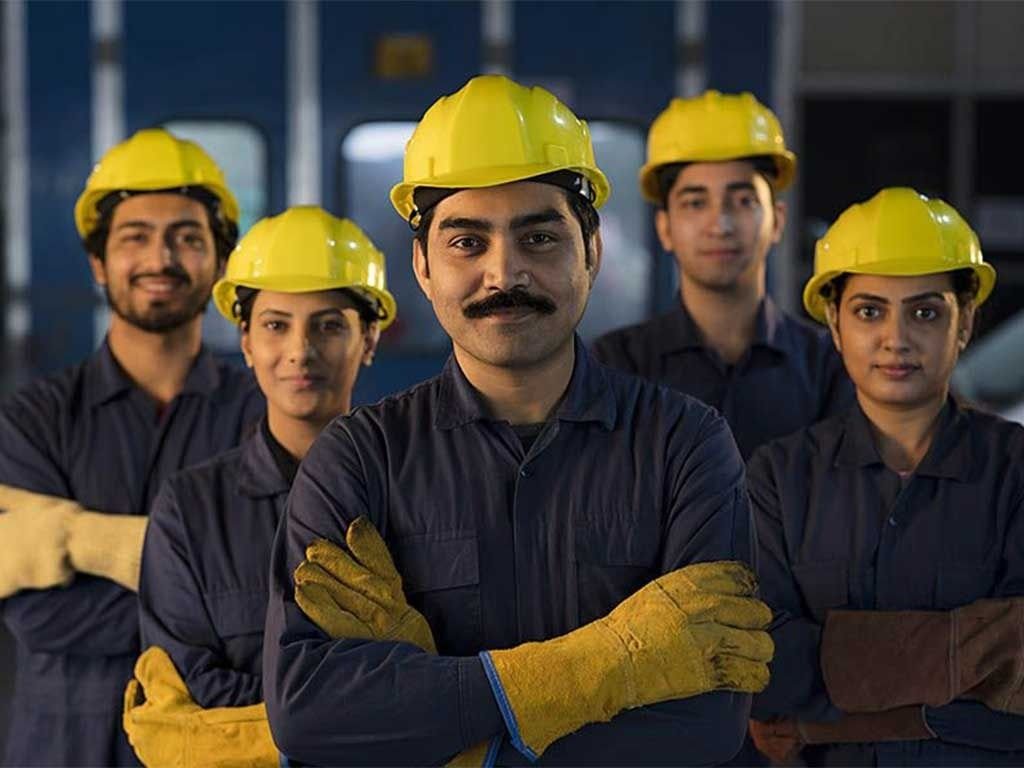 Five RIFS fire and safety trainees in yellow safety helmets and gloves standing together